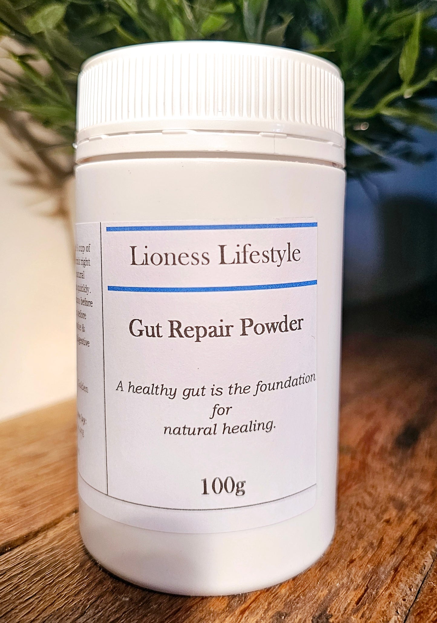 Lioness Lifestyle Gut Repair Powder 100g container on rustic wood table – natural gut health supplement for digestion, healing, and microbiome balance
