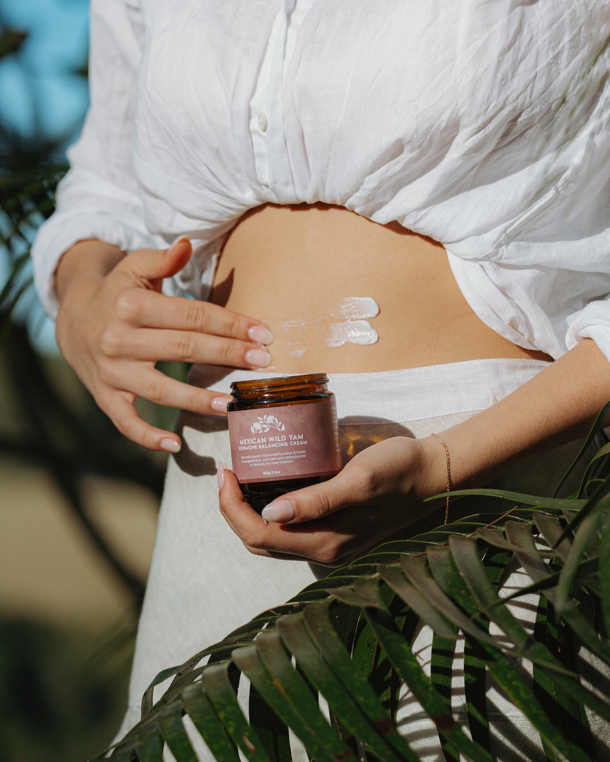 Woman applying Mexican Wild Yam Hormone Balancing Cream to abdomen – natural topical support for hormone regulation and menstrual wellness