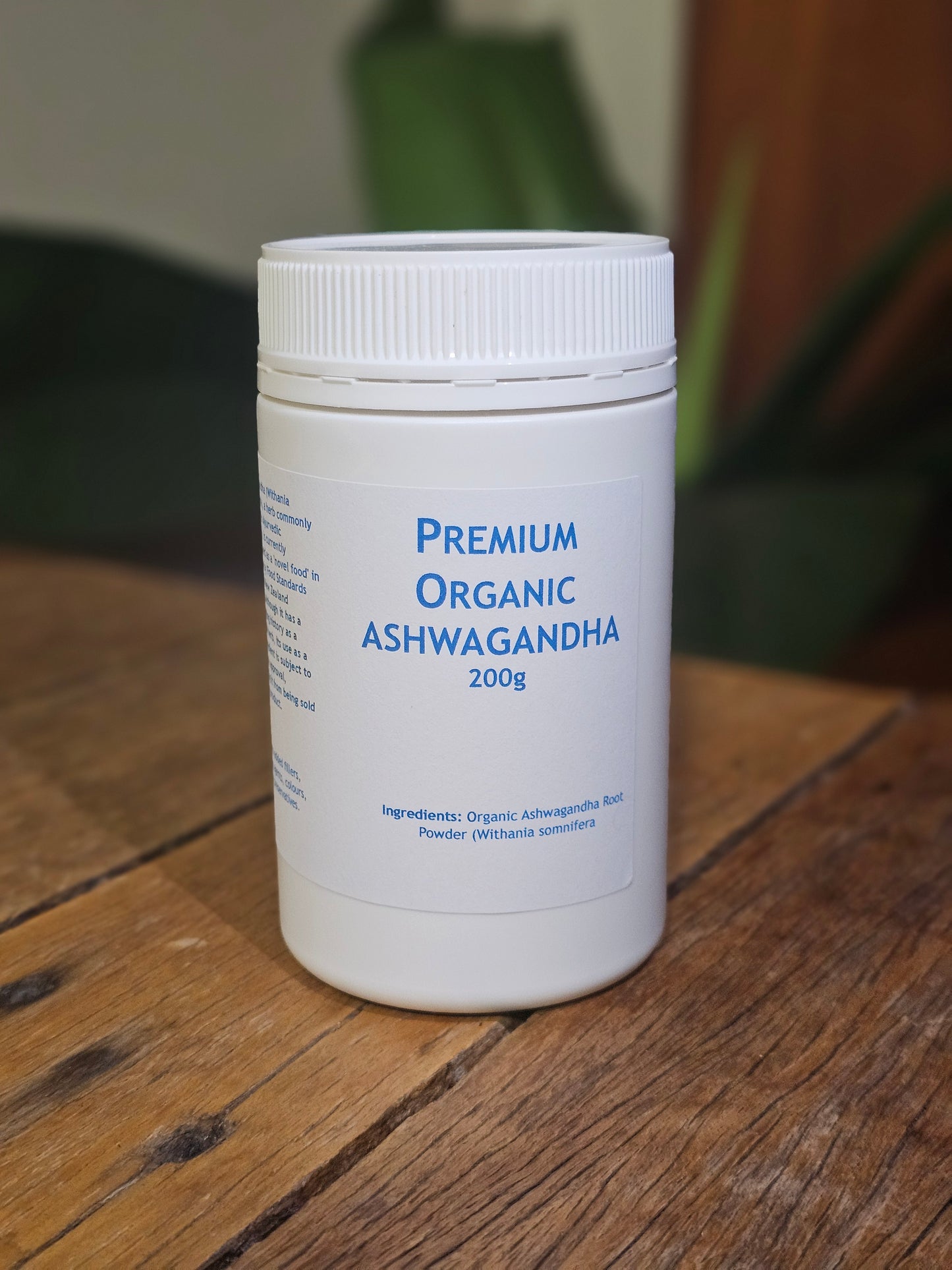 "Premium Organic Ashwagandha 200g container with pure Withania somnifera root powder, natural stress relief supplement on wooden surface with green wellness-themed background"