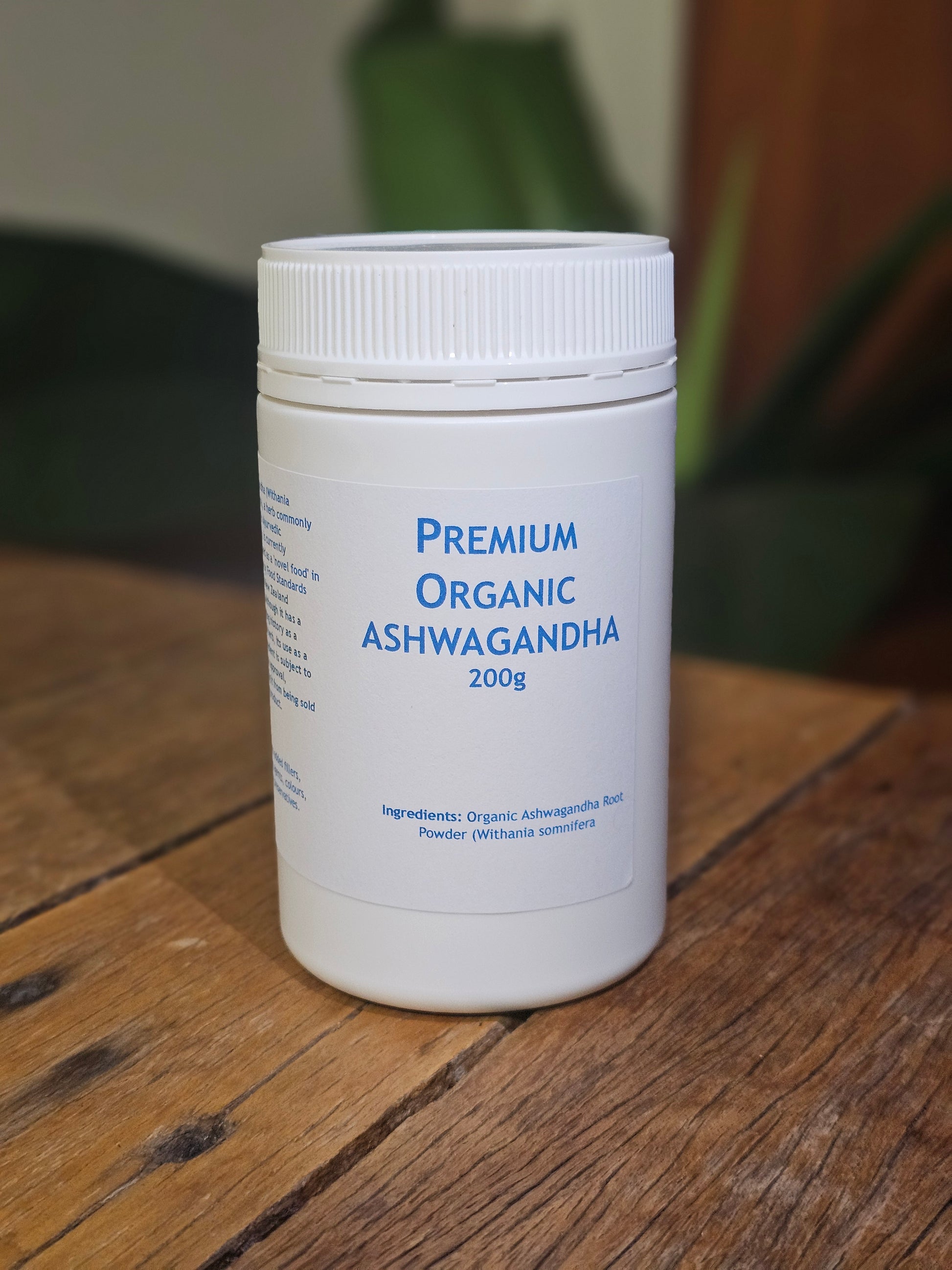 "Premium Organic Ashwagandha 200g container with pure Withania somnifera root powder, natural stress relief supplement on wooden surface with green wellness-themed background"